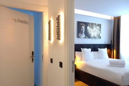 a hotel room with a bed with white pillows at Woohoo Rooms Unique Madrid in Madrid