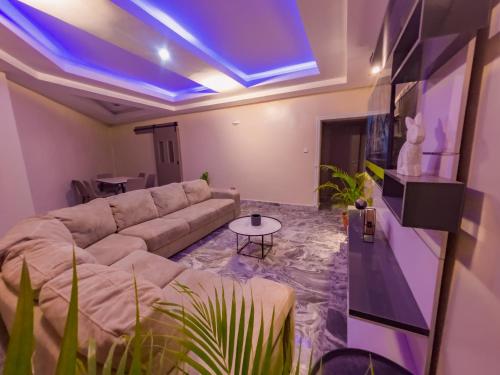 a living room with a couch and a blue ceiling at 154 Apartments and Hotel in Abuja