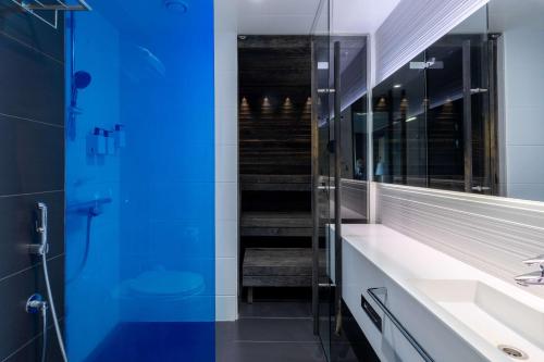 a bathroom with a sink and a blue shower at Scandic Tampere Station in Tampere