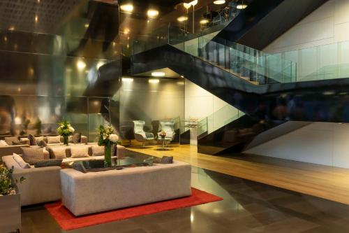 a living room with couches and a staircase at NH Collection Barcelona Constanza in Barcelona