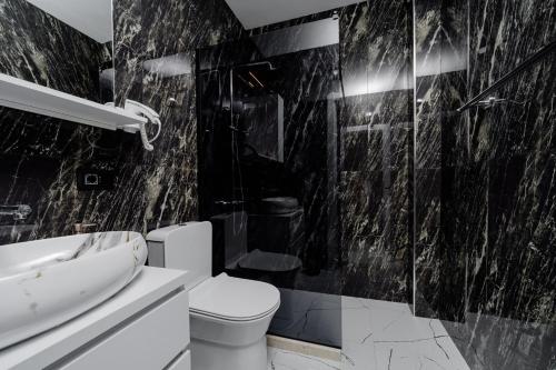 a black and white bathroom with a toilet and a sink at Aurora Apartments in Bar