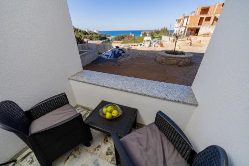 a balcony with two chairs and a bowl of fruit on a table at Aurora Apartments in Bar