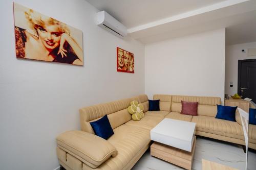 a living room with a tan couch and blue pillows at Aurora Apartments in Bar