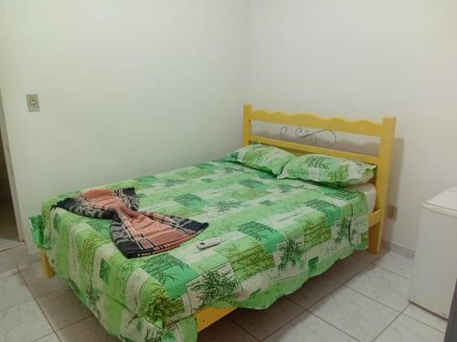 a bedroom with a bed with a green comforter at Vila Preá in Prea