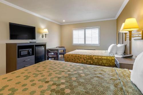 a hotel room with two beds and a flat screen tv at Econo Lodge Moreno Valley in Moreno Valley