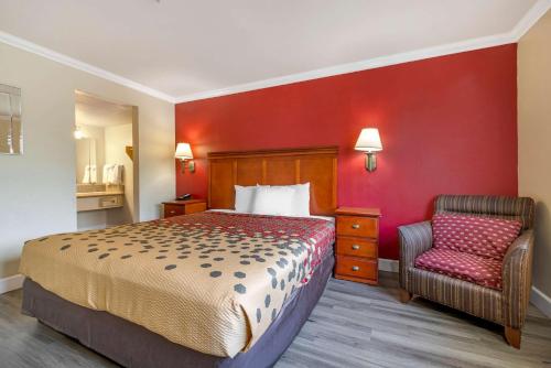 a hotel room with a bed and a chair at Econo Lodge Moreno Valley in Moreno Valley