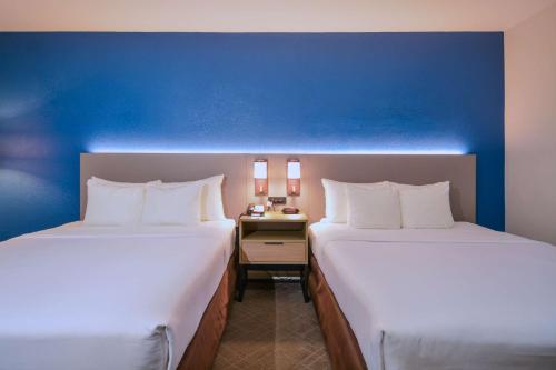two beds in a room with a blue wall at Comfort Inn & Suites Moreno Valley near March Air Reserve Base in Moreno Valley