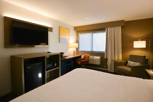 a hotel room with a bed and a flat screen tv at Comfort Inn & Suites Moreno Valley near March Air Reserve Base in Moreno Valley