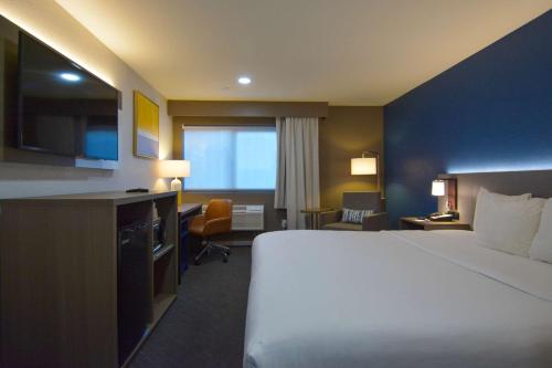 a hotel room with a large bed and a television at Comfort Inn & Suites Moreno Valley near March Air Reserve Base in Moreno Valley