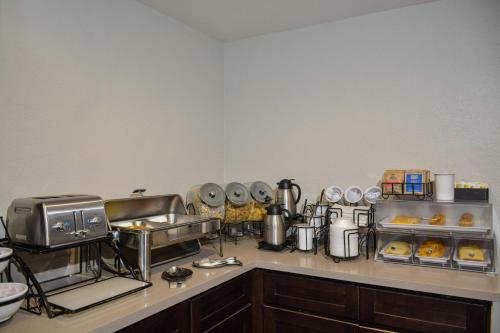 a kitchen with a counter with a bunch of food at Comfort Inn & Suites Moreno Valley near March Air Reserve Base in Moreno Valley