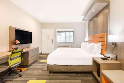 a hotel room with a bed and a desk and a tv at Rodeway Inn near Melrose Ave in Los Angeles