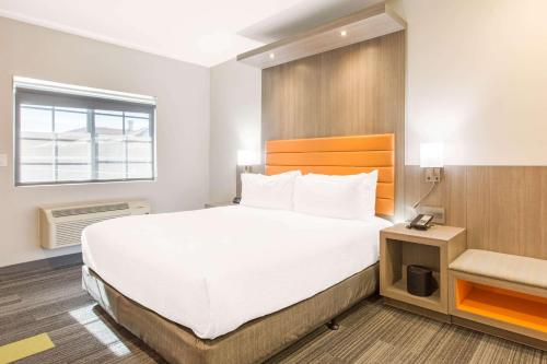 a hotel room with a large bed and a window at Rodeway Inn near Melrose Ave in Los Angeles