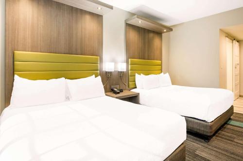 two beds in a hotel room with white sheets at Rodeway Inn near Melrose Ave in Los Angeles