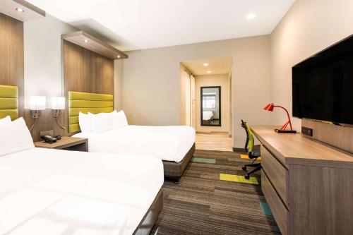 a hotel room with two beds and a flat screen tv at Rodeway Inn near Melrose Ave in Los Angeles