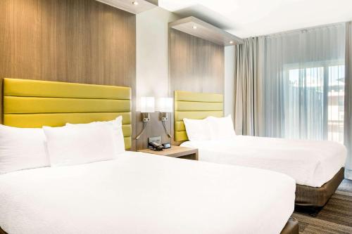 a hotel room with two beds and a window at Rodeway Inn near Melrose Ave in Los Angeles