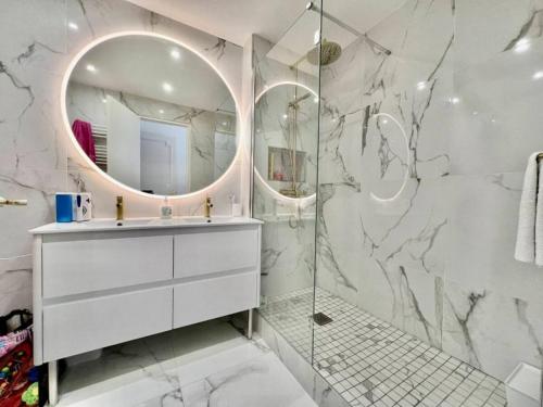 une salle de bain blanche avec un lavabo et un miroir dans l'établissement 90 m2, 5 min walk to Croisette, Basse Californie, à Cannes