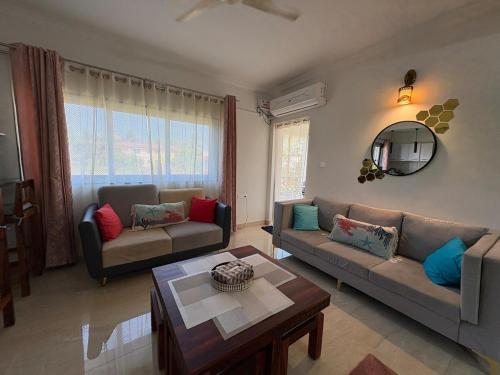 un soggiorno con due divani e un tavolo di The Greendoor Villa - ByLaMer, 500mtrs Zalor Beach a Varca