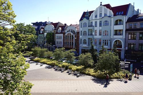 a large building with a garden in front of it at Makas Apartamenty in Świnoujście