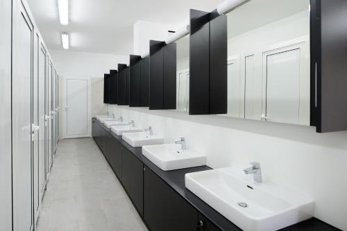 a bathroom with a row of sinks and mirrors at Medora Orbis Camping Pitches in Podgora