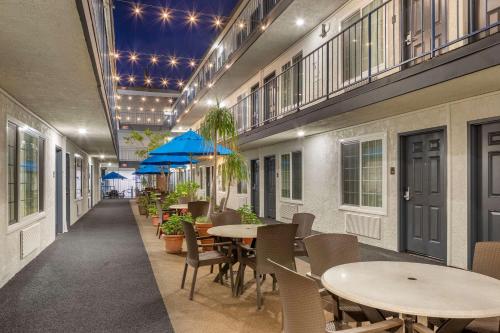 a restaurant with tables and chairs and blue umbrellas at Comfort Inn Santa Monica - West Los Angeles in Los Angeles