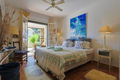 une chambre avec un lit et un ventilateur de plafond dans l'établissement Val de Mer - Piscine et Grand Jardin, à La Croix-Valmer