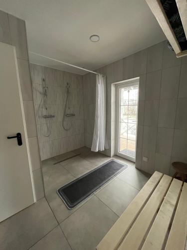 a bathroom with two showers and a bath tub at Pirties namelis Paliekys in Lekėčiai