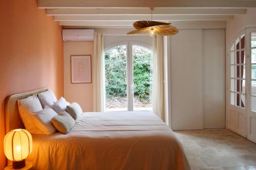 a bedroom with a bed with a ceiling fan and a window at Villa l'Insolente Spa Sauna Chambre 50 nuances de Grey in Lembras