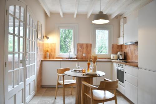 une cuisine avec une table et des chaises dans une pièce dans l'établissement Villa l'Insolente Spa Sauna Chambre 50 nuances de Grey, à Lembras