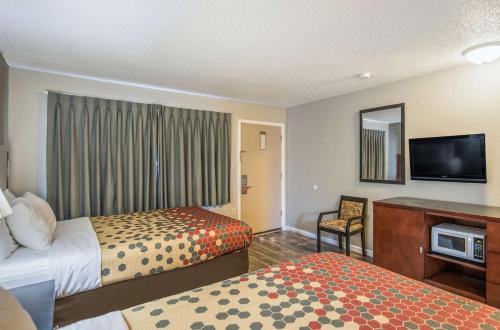 a hotel room with two beds and a flat screen tv at Econo Lodge Inn & Suites Yreka in Yreka
