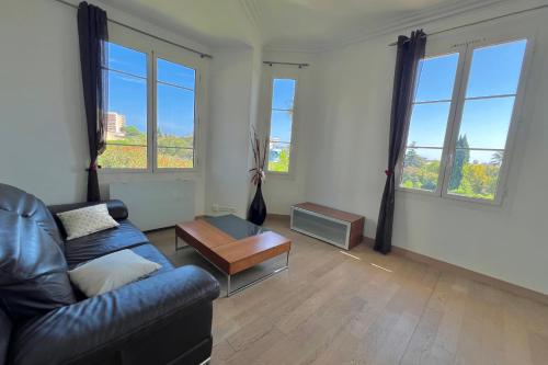 - un salon avec un canapé, une table et des fenêtres dans l'établissement JUAN LES PINS 6 people pool tennis, à Juan-les-Pins