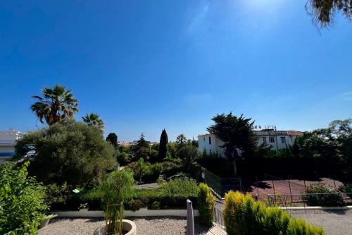 Elle offre une vue sur un jardin planté d'arbres et de buissons. dans l'établissement JUAN LES PINS 6 people pool tennis, à Juan-les-Pins
