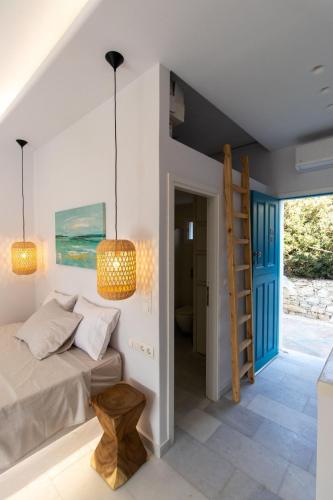 a bedroom with a bed and a ladder and a staircase at Ammos Studio Pyrgaki Naxos in Agiassos