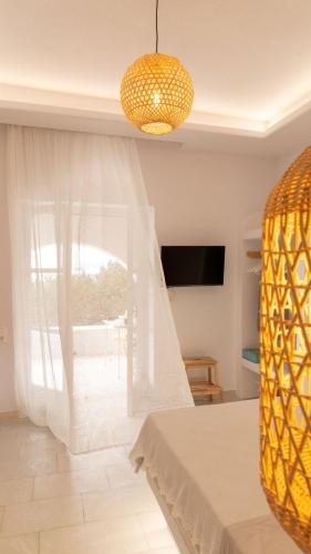 a dining room with a table and a chandelier at Ammos Studio Pyrgaki Naxos in Agiassos