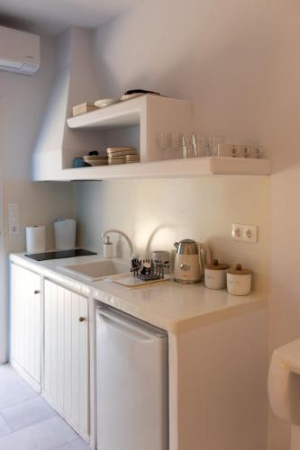 a white kitchen with a sink and a counter top at Ammos Studio Pyrgaki Naxos in Agiassos