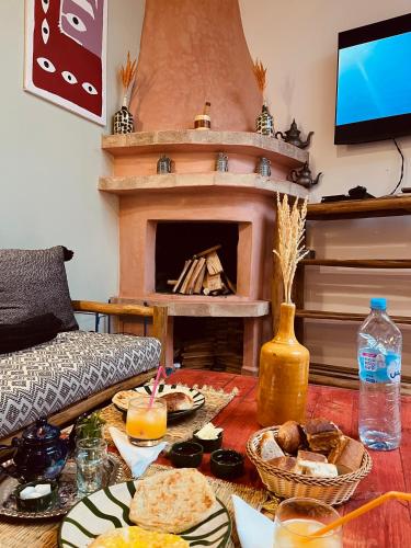 a living room with a table with food and a fireplace at hostel riad maqam in Essaouira