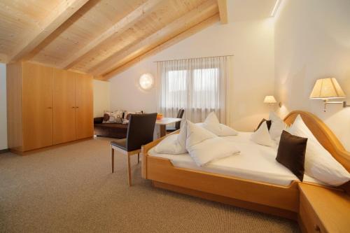a hotel room with a bed and a table at Garni Unterhaslerhof in Merano