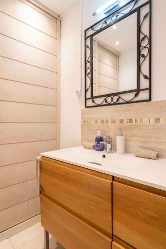 une salle de bain avec un lavabo et un miroir dans l'établissement Charming flat, fully equipped, beach only 300m - LA LOGE, à Nice