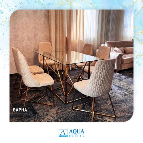 a dining room with a glass table and chairs at Aqua Hotel in Varna City