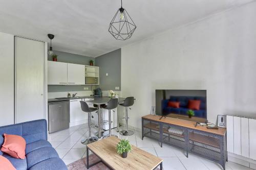 un salon avec un canapé bleu et une cuisine dans l'établissement Bel appartement au calme Paris Disney, à Bussy-Saint-Georges