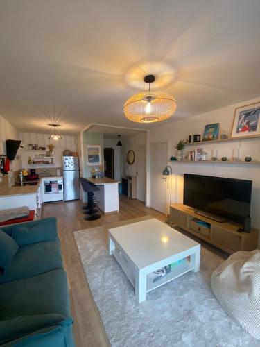 un salon avec un canapé et une table basse dans l'établissement Appartement à 15 min à pied du vieux port, à La Rochelle