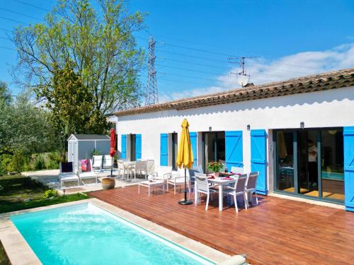 une maison avec une terrasse en bois et une piscine dans l'établissement Villa Malia - Luxury Designer House in Mougins, à Mougins