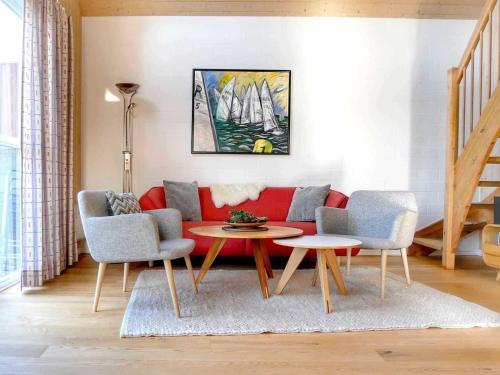 a living room with a red couch and two chairs and a table at Ferienpark Scharmützelsee in Wendisch Rietz