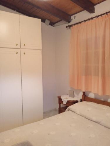 a bedroom with a bed and a dresser and a window at Niki's House in Gythio