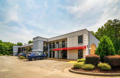 a building with a car parked in a parking lot at Econo Lodge Research Triangle Park in Durham