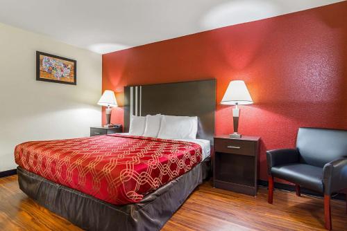 a hotel room with a bed and a chair at Econo Lodge Research Triangle Park in Durham