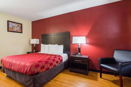 a hotel room with a bed and a red wall at Econo Lodge Research Triangle Park in Durham