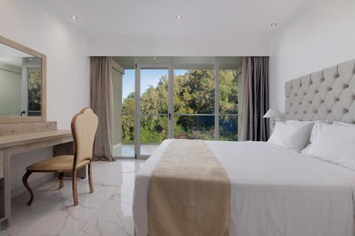 a bedroom with a bed and a desk and a window at Mythos Panorama - Adults Only in Boukari