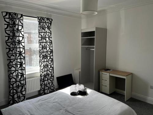 a bedroom with a bed and a desk and a window at ResiLets - Ground Plessey Road Apt in Cowpen