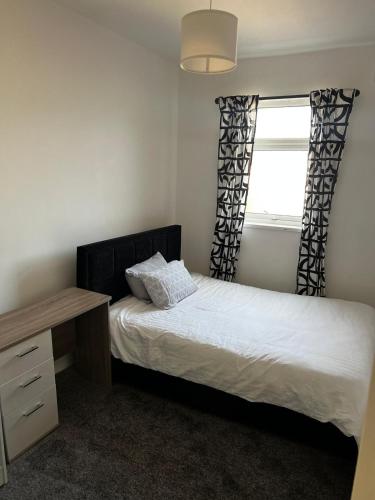a bedroom with a bed and a desk and a window at ResiLets - Ground Plessey Road Apt in Cowpen