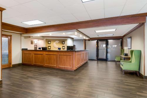 an office lobby with a reception desk and green chairs at Comfort Inn South Oceanfront in Nags Head
